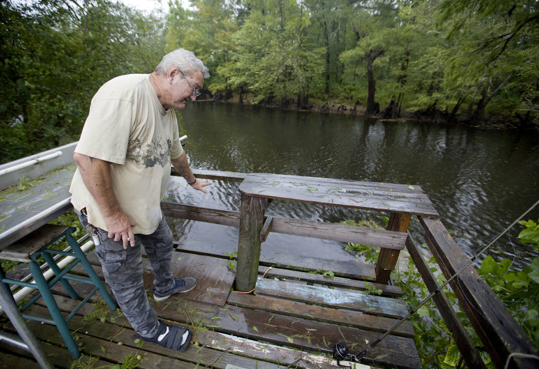 Bennie Todd shows how high the Lumber River rose during Hurricane Matthew two years in his backyard in Lumberton, N.C., Friday, Sept. 14, 2018. Now the town is bracing for another potentially cata ...