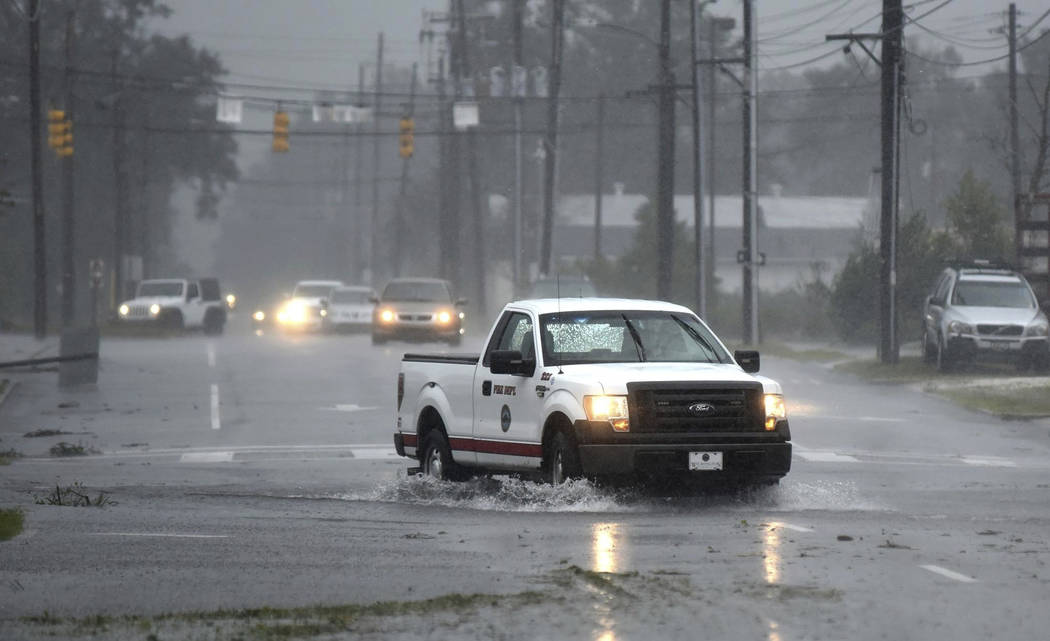 A vehicle with the Wilmington Fire Department drives through a flooded street from Florence, now a tropical storm in Wilmington, N.C., Saturday, Sept. 15, 2018. (Matt Born/The Star-News via AP)