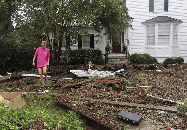Resident Alice Tolson steps over storm debris that washed up from the Neuse River at her home on East Front Street in New Bern, N.C., Saturday, Sept. 15, 2018, after Hurricane Florence sweeps over ...