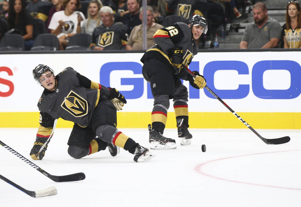 Golden Knights defenseman Erik Brannstrom (12) gets tripped up next to Golden Knights left wing Tomas Nosek (92) during the second period of a preseason NHL hockey game against the Arizona Coyotes ...