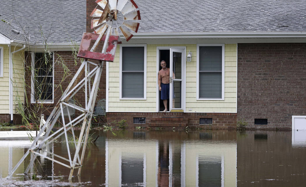 A man peers from his flooded home in Lumberton, N.C., Sunday, Sept. 16, 2018, in the aftermath of Hurricane Florence. (AP Photo/Gerry Broome)