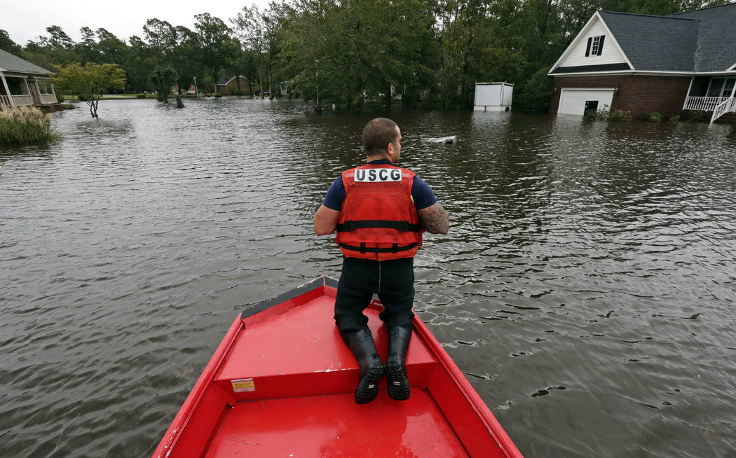 Petty Officer Second Class David Kelley patrols a flooded neighborhood in Lumberton, N.C., Sunday, Sept. 16, 2018, following flooding from Hurricane Florence. (AP Photo/Gerry Broome)