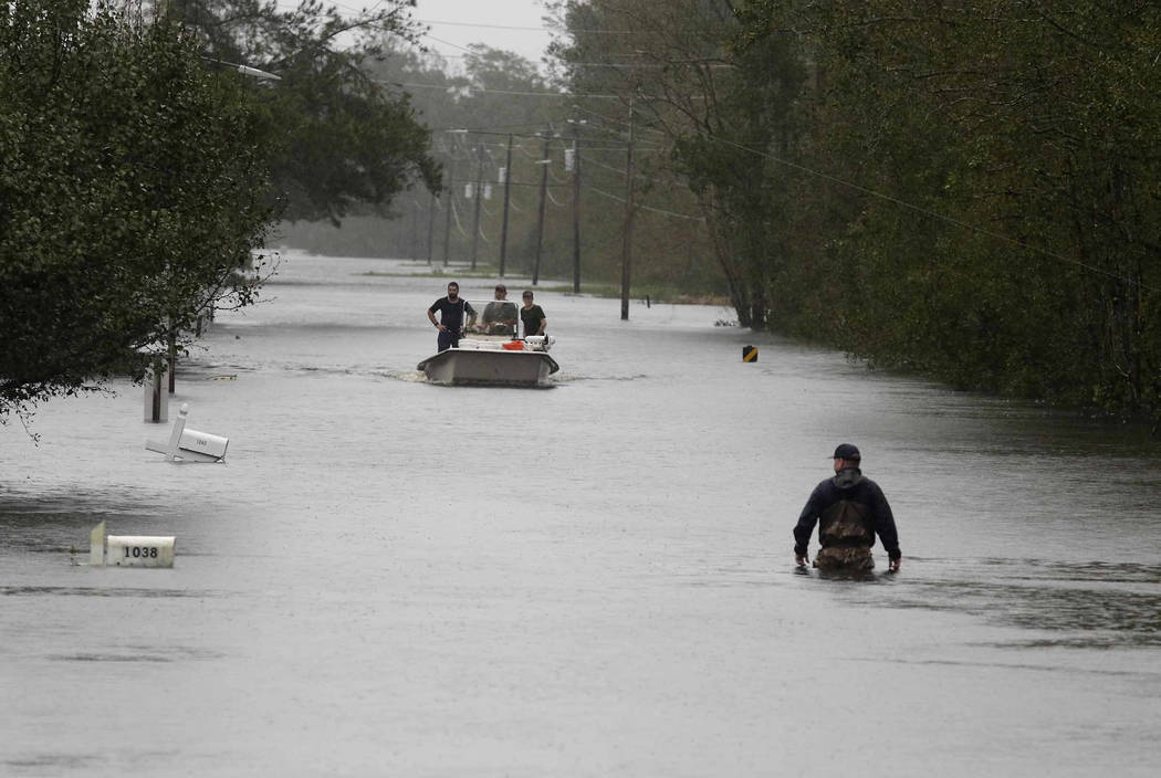 A member of the U.S. Coast Guard walks down Mill Creek Road checking houses after tropical storm Florence hit Newport N.C., Saturday, Sept. 15, 2018. (AP Photo/Tom Copeland)