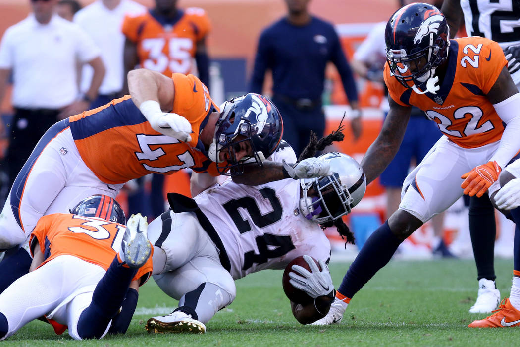 Oakland Raiders running back Marshawn Lynch (24)is tackled by Denver Broncos linebacker Josey Jewell (47) and defensive back Justin Simmons (31) during the second half of their NFL game in Denver, ...