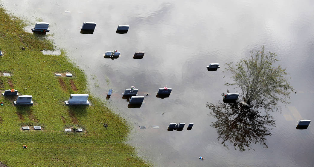 Tombstones sit submerged in floodwaters from Hurricane Florence, in a cemetery in Marion, S.C., Monday, Sept. 17, 2018. (AP Photo/Gerald Herbert)