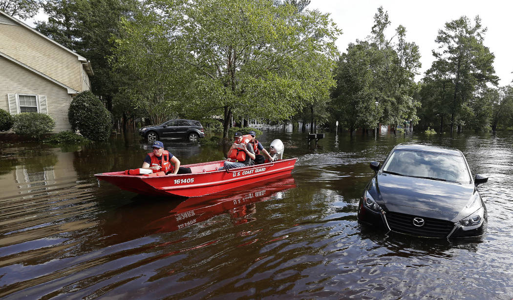 Members of the U.S. Coast Guard Shallow Water Rescue Team check on a flooded neighborhood in Lumberton, N.C., Monday, Sept. 17, 2018, in the aftermath of Hurricane Florence. (AP Photo/Gerry Broome)