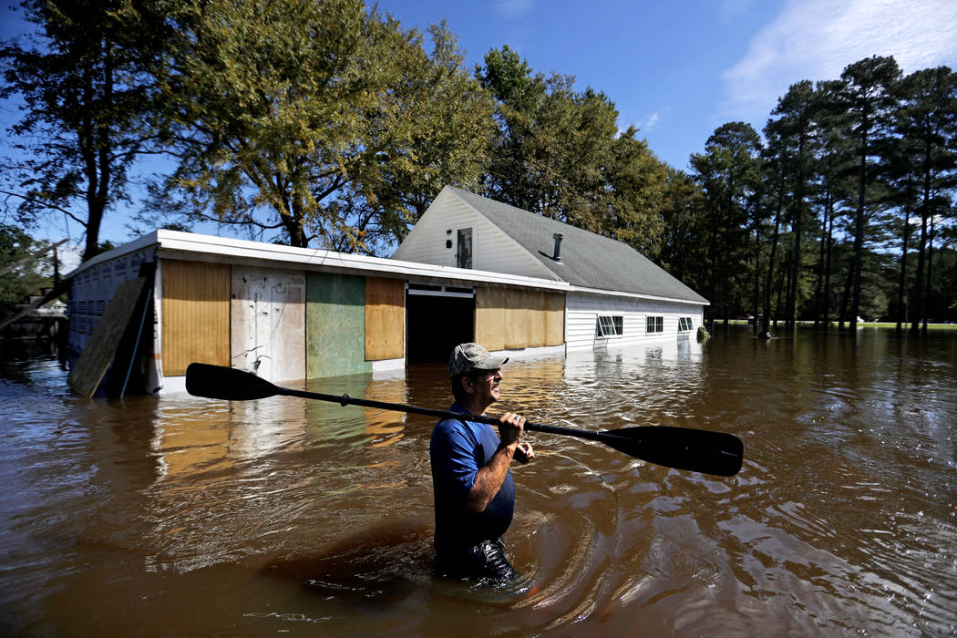 Kenny Babb retrieves a paddle that floated away on his flooded property as the Little River continues to rise in the aftermath of Hurricane Florence in Linden, N.C., Tuesday, Sept. 18, 2018. (Davi ...