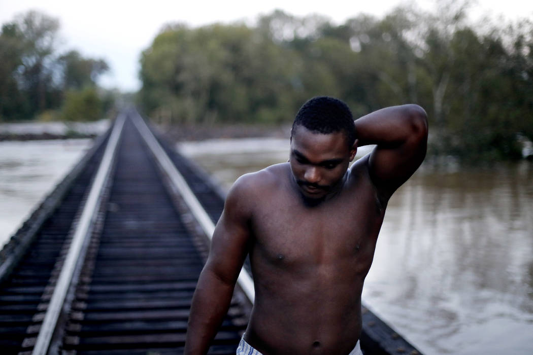 Russell Maloy walks over a railway bridge near his home to check the level of the Cape Fear River which has been rising in the aftermath of Hurricane Florence in Fayetteville, N.C., Tuesday, Sept. ...