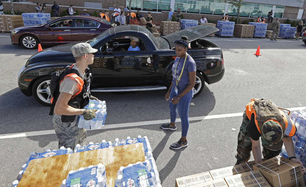 Members of the Civil Air Patrol load cars with MREs (Meals Ready To Eat), water and tarps at distribution area in Wilmington, N.C. Tuesday, Sept. 18, 2018. (Chuck Burton/AP)