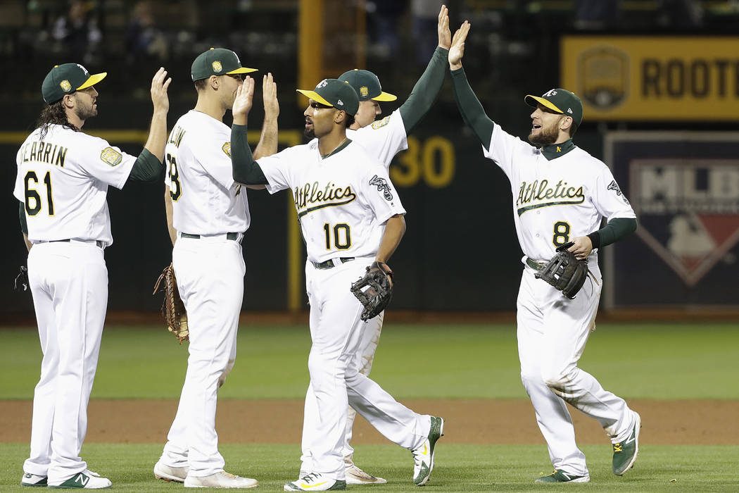 Oakland Athletics' Cody Gearrin, from left, celebrates with Matt Olson, Marcus Semien and Jed Lowrie after beating the New York Yankees in a baseball game in Oakland, Calif., Wednesday, Sept. 5, 2 ...