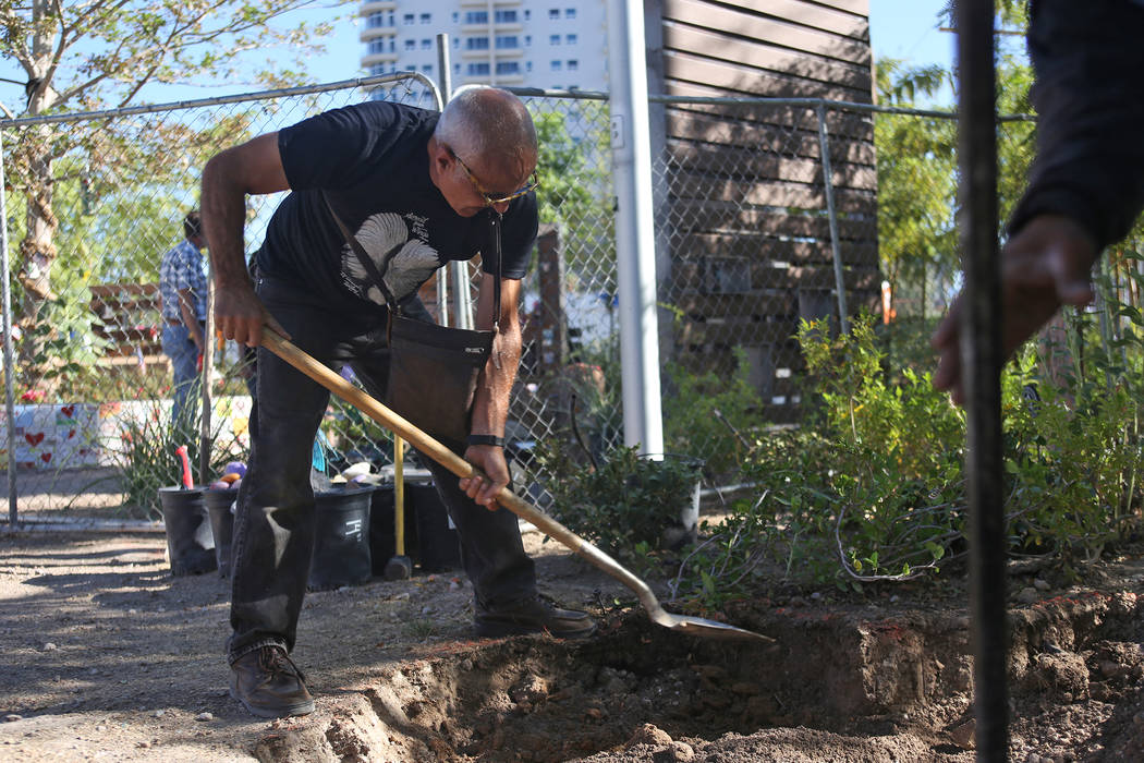 Artist Bobby Jacobs digs a deeper pit for the installation of a stone sculpture he created in the Healing Garden in Las Vegas, Thursday, Sept. 20, 2018. The back of the wings of the sculpture have ...