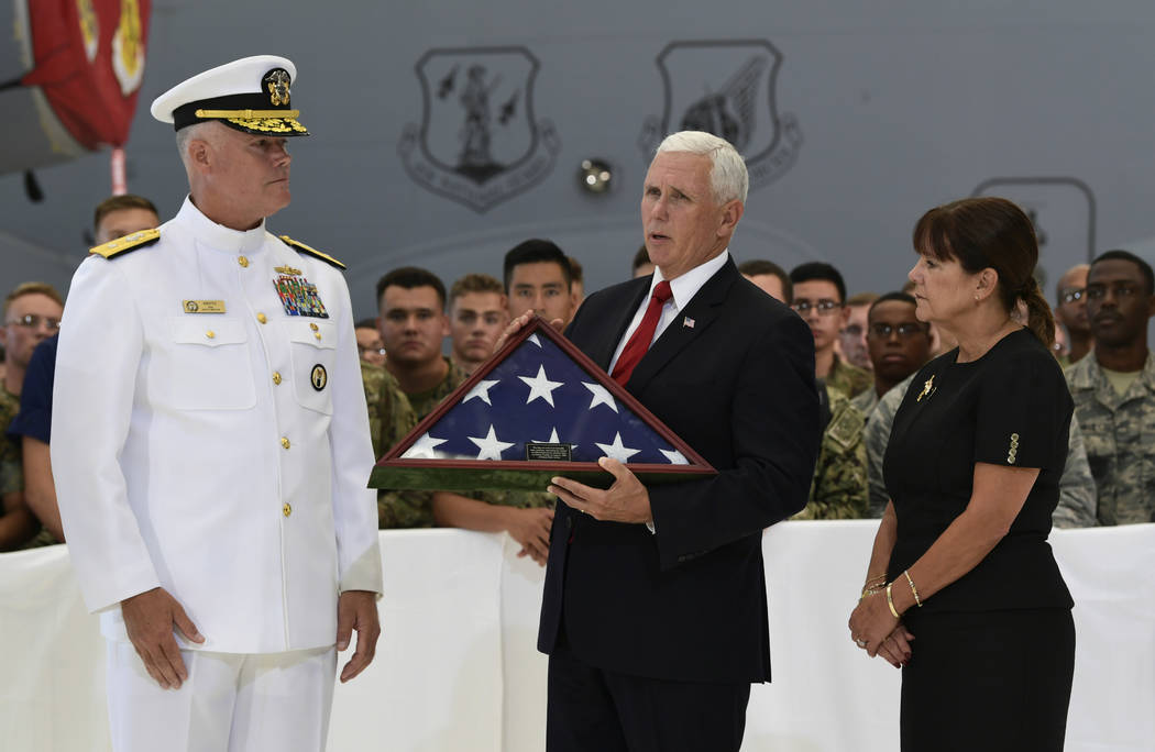 Vice President Mike Pence, center, receives a flag from Navy Rear Adm. Jon Kreitz, deputy director of the POW/MIA Accounting Agency, left, during a visit to Joint Base Pearl Harbor-Hickam in Hawai ...