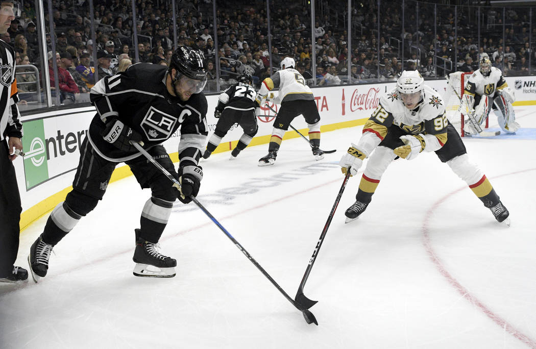 Los Angeles Kings center Anze Kopitar, left, of Slovenia, and Vegas Golden Knights center Tomas Nosek, of the Czech Republic, reach for the puck during the third period of a preseason NHL hockey g ...