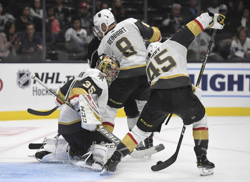 Vegas Golden Knights goalie Oscar Dansk, of Sweden, and defenseman Jake Bischoff (45) clear the puck from the front of the net during the third period of their 7-2 win over the Los Angeles Kings i ...