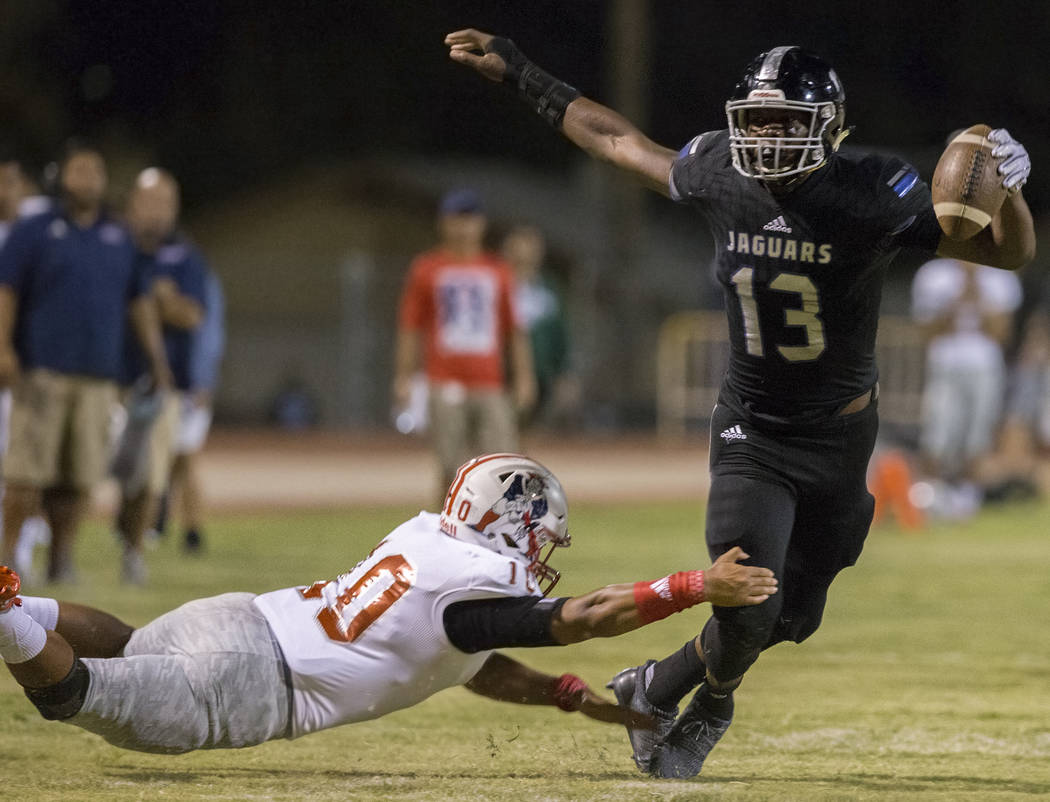 Desert Pines junior tight end Darnell Washington (13) breaks the tackle of Liberty sophomore linebacker Zephania Maea (3) in the second quarter during the Jaguars home game with the Patriots on Fr ...
