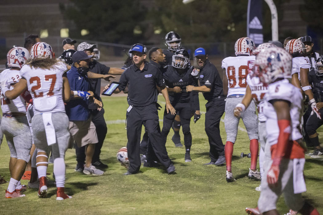 Coaches try and break up a fight in the third quarter during the Liberty Patriots road game with the Desert Pines Jaguars on Friday, Sept. 21, 2018, at Desert Pines High School, in Las Vegas. Benj ...