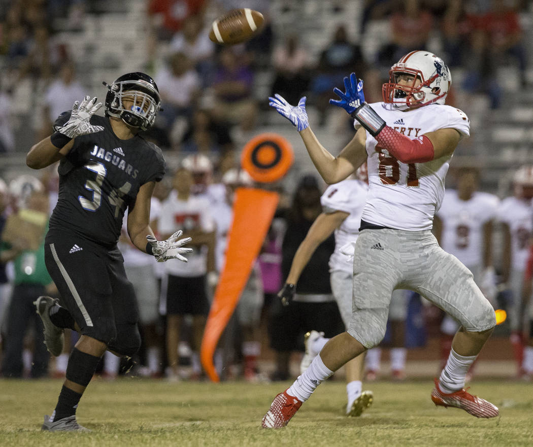 Liberty sophomore tight end Moliki Matavao (81) makes a reception over Desert Pines sophomore Nikolas Salter (34) in the fourth quarter during the Patriots road game with the Jaguars on Friday, Se ...