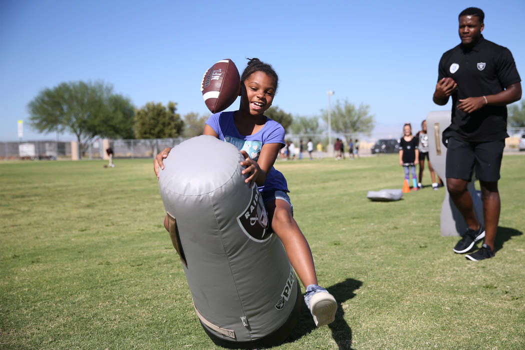 Third grade student Camille Jones, 8, left, participates in a Raiders youth football camp at Robert Taylor Elementary School in Henderson, Tuesday, Sept. 25, 2018. The Raiders adopted a Communitie ...