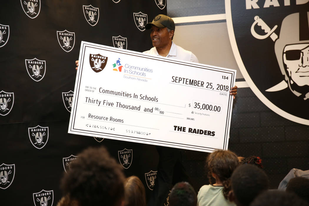 Raiders alumni Leo Gray presents a donation of $35,000 to Communities In Schools of Nevada during an event at Robert Taylor Elementary School in Henderson, Tuesday, Sept. 25, 2018. The Raiders ado ...