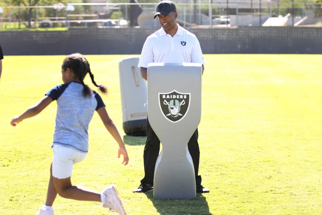 Raiders alumni Leo Gray, right, participates in a youth football camp event at Robert Taylor Elementary School in Henderson, Tuesday, Sept. 25, 2018. The Raiders adopted the Communities In Schools ...