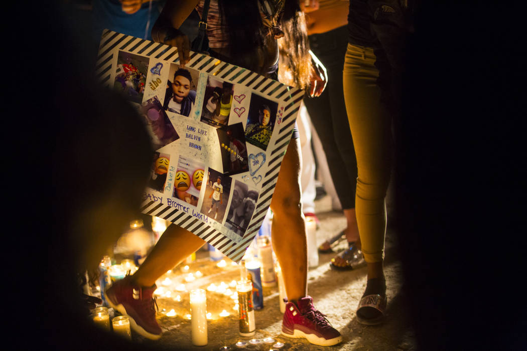 A poster with photos of Canyon Springs student Dalvin Brown, who was shot and killed this past Tuesday, is displayed during a candlelight vigil outside of the school at Alexander Road and North 5t ...