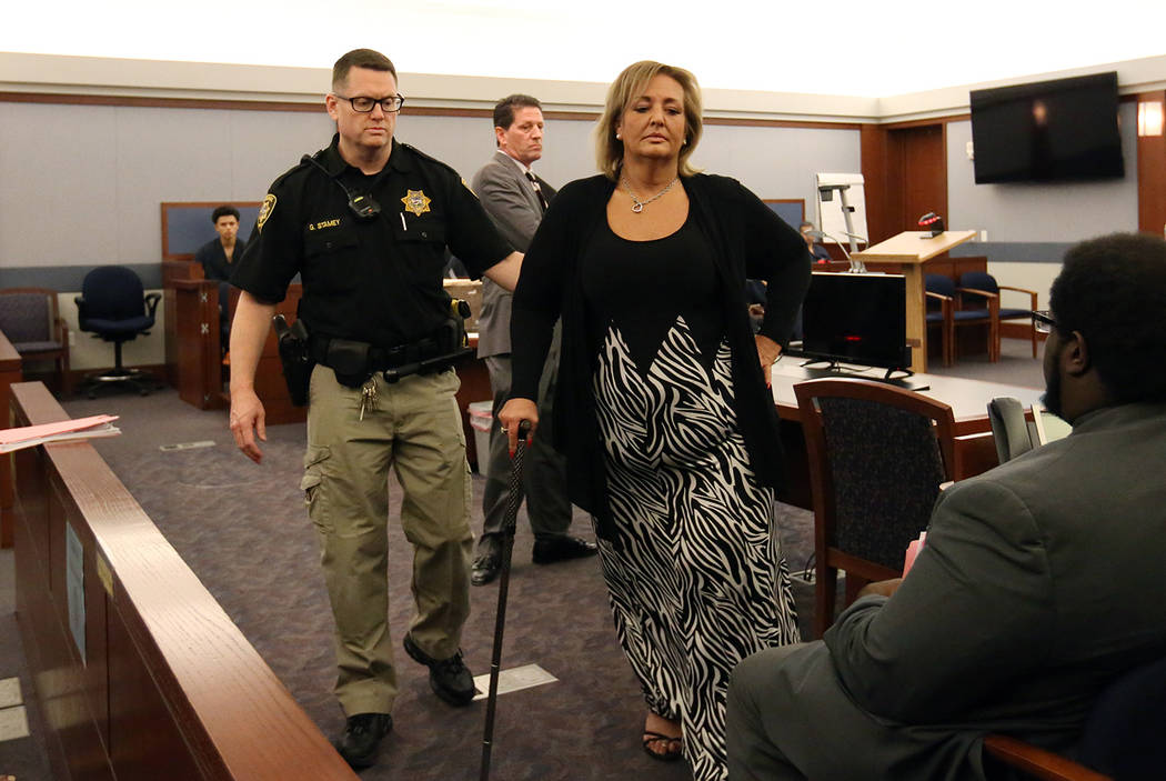 Vicki Greco, right, a suspended Las Vegas attorney who pleaded guilty to three felonies for her role in a scheme to defraud the court system, led out of the courtroom after her sentencing as her d ...