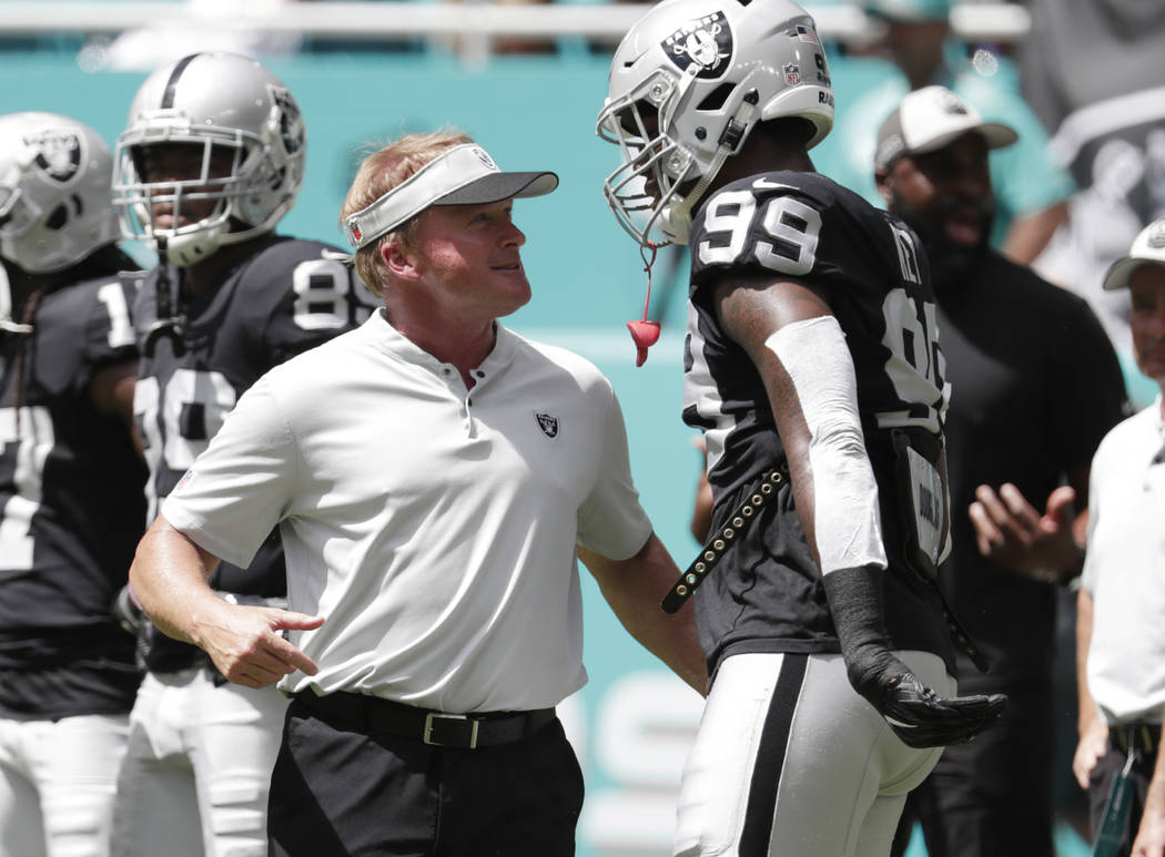 Oakland Raiders head coach Jon Gruden talks with defensive end Arden Key (99) before the start of an NFL football game against the Miami Dolphins, Sunday, Sept. 23, 2018 in Miami Gardens, Fla. (AP ...