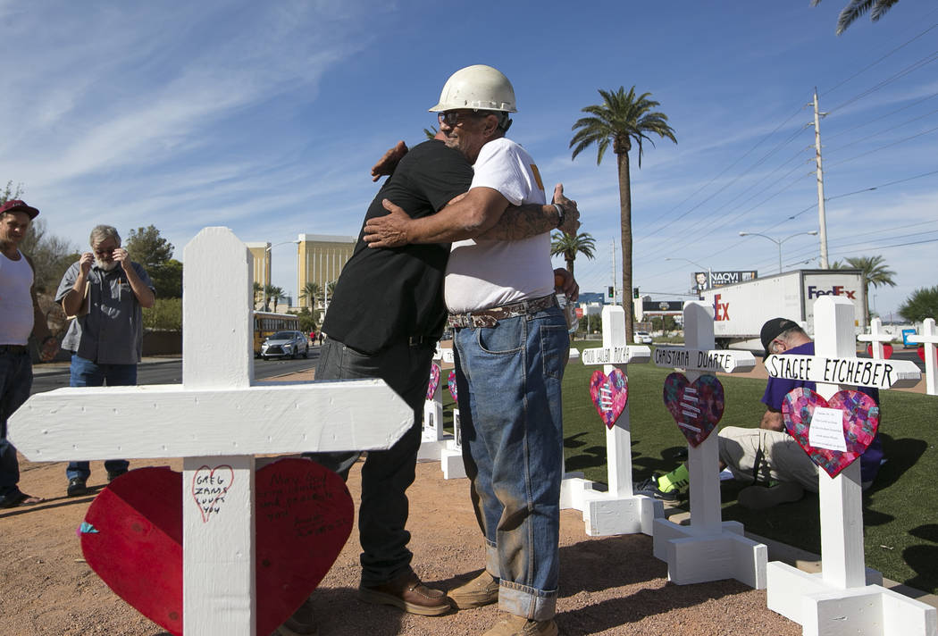 Cross maker Greg Zanis, right, gets a hug from Mike Warino, brother of Oct.1 shooting victim Heather Alvarado, near the Welcome to Fabulous Las Vegas sign on Friday, Sept. 28, 2018. Zanis gave War ...