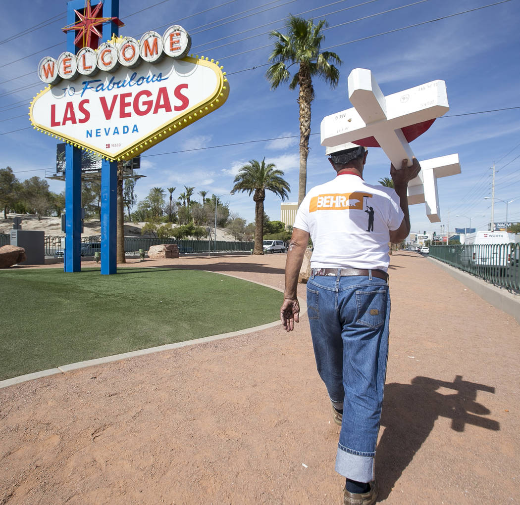 Greg Zanis, of Aurora, Ill., carries one of 58 crosses he placed near the Welcome to Fabulous Las Vegas sign honoring victims of the Oct.1 shooting on Friday, Sept. 28, 2018. Monday marks the one- ...