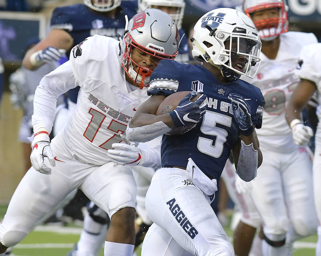 Utah State running back Darwin Thompson (5) carries the ball for a 7-yard touchdown, next to UNLV defensive back Evan Austrie (17) during an NCAA college football game Saturday, Oct. 13, 2018, in ...