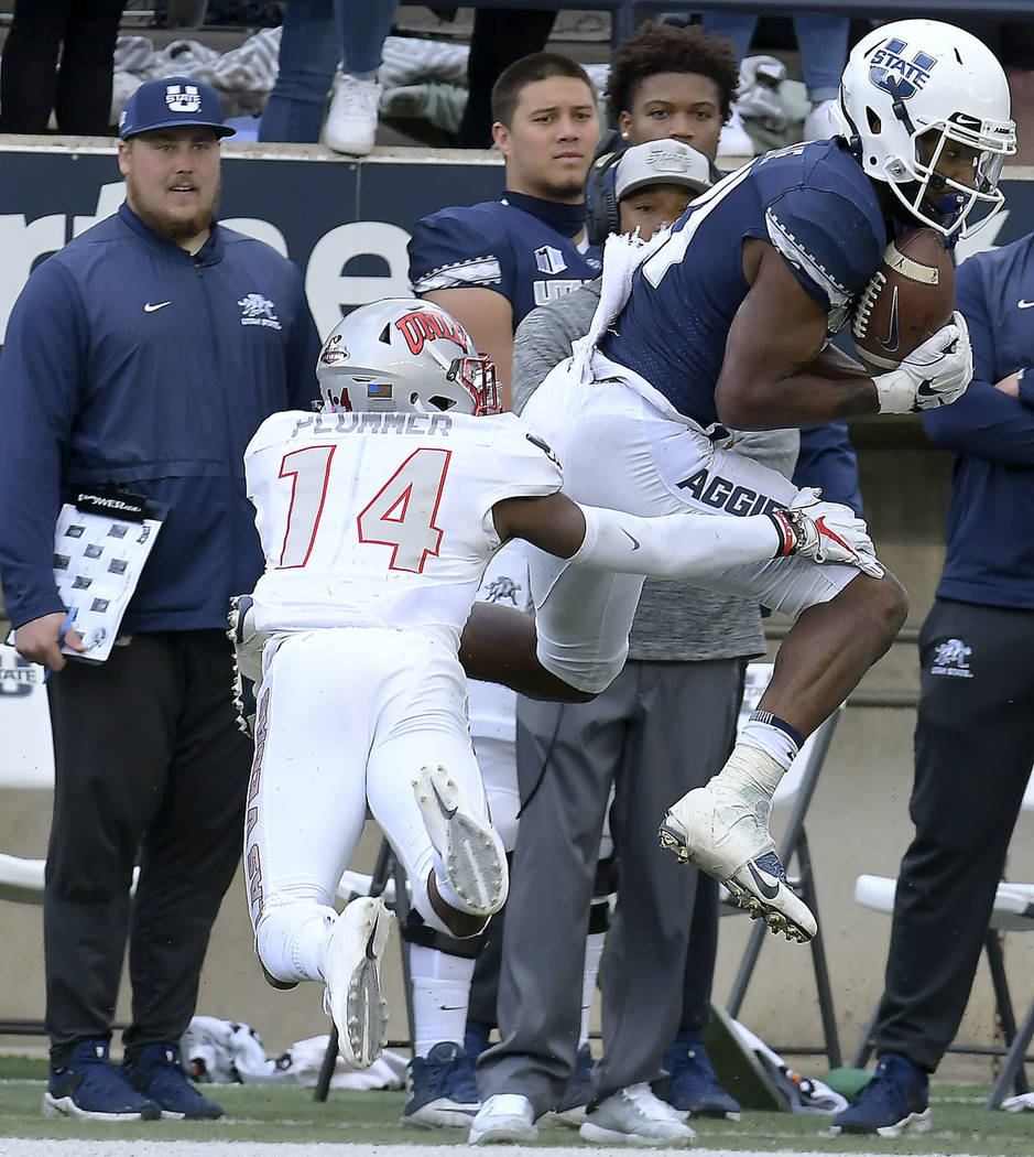 Utah State wide receiver Jalen Greene (21) catches a pass next to UNLV defensive back Myles Plummer during an NCAA college football game Saturday, Oct. 13, 2018, in Logan, Utah. (Eli Lucero/The He ...
