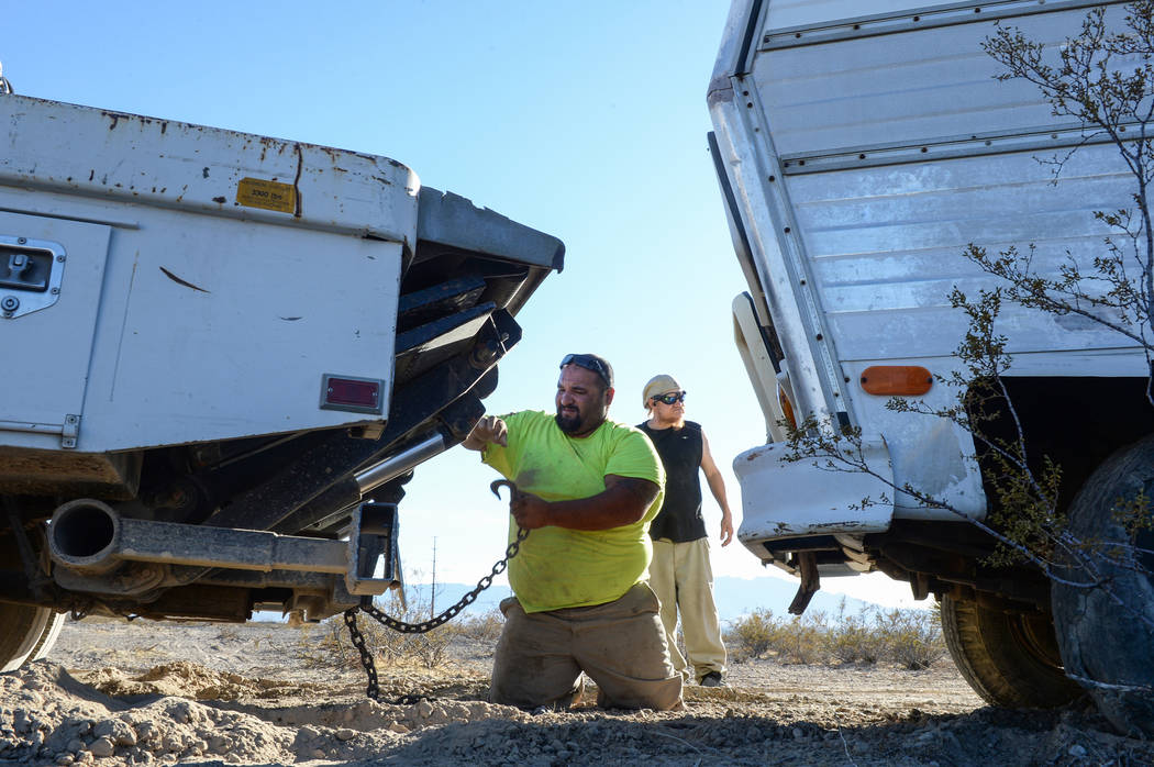 Jon Olivas of Platinum Hauling unhooks the chain linking his truck to Mary Supples' trailer in ...