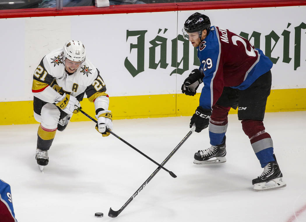 Vegas Golden Knights center Cody Eakin (21) and Colorado Avalanche center Nathan MacKinnon (29) go after the puck during the first period of a preseason NHL hockey game, Tuesday, Sept. 18, 2018, i ...
