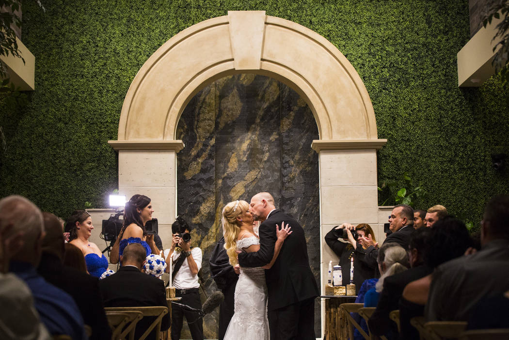 Oshia Collins-Waters, left, kisses Todd Wienke during their wedding ceremony at Chapel of the Flowers in Las Vegas on Monday, Oct. 1, 2018. Todd was shot three times as he shielded Oshia soon afte ...