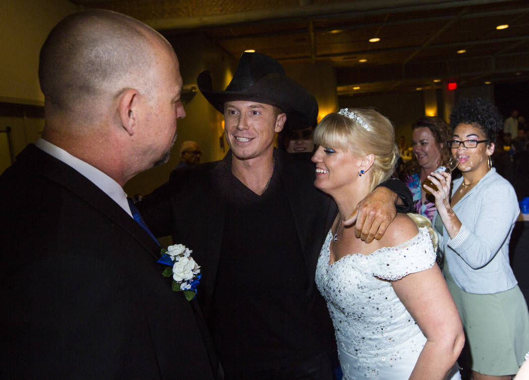 Country musician Sam Riddle, center, greets Todd and Oshia Wienke during their wedding reception at Tahiti Village in Las Vegas on Monday, Oct. 1, 2018. Todd was shot three times as he shielded Os ...