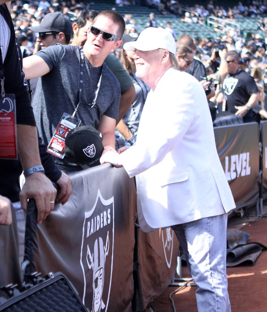 Oakland Raiders owner Mark Davis poses for a photo with Clark County fireman Robert Marquis in Oakland, Calif., Sunday, Sept. 30, 2018. First responders were invited to the game against the Clevel ...