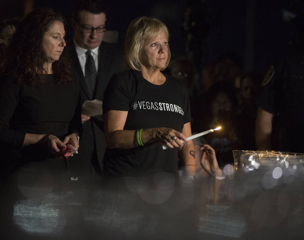 Esther Reincker, right, and Mauricia Baca light candles for the 58 victims of the Oct 1 shooting at 10:05 p.m., the exact time the shooting began last year, during a ceremony organized by the City ...