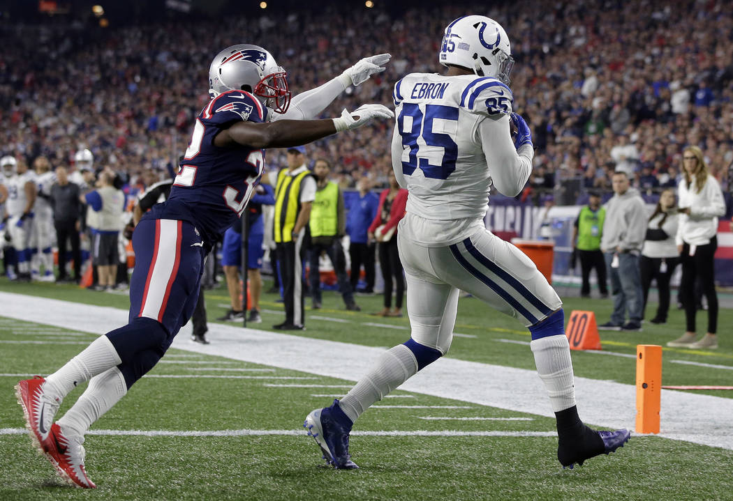 Indianapolis Colts tight end Eric Ebron (85) catches a touchdown pass as New England Patriots defensive back Devin McCourty, left, defends during the second half of an NFL football game, Thursday, ...