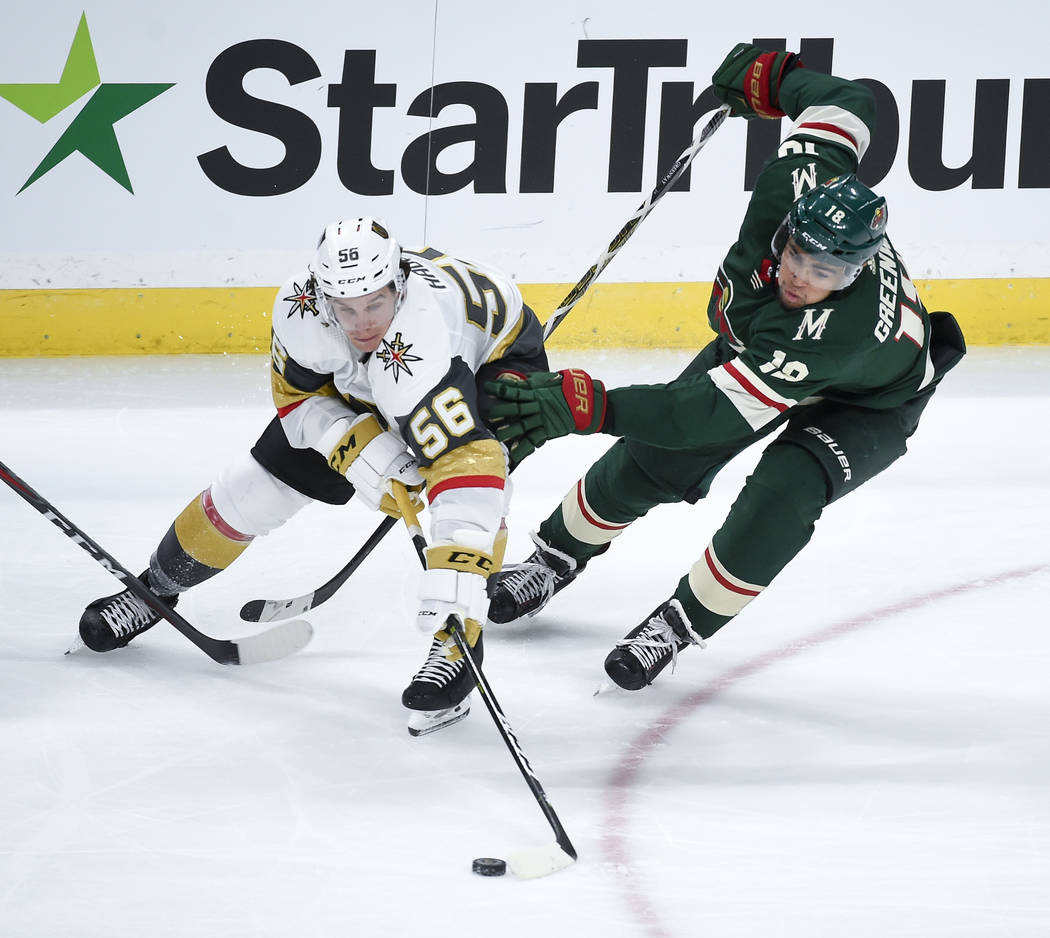 Vegas Golden Knights left wing Erik Haula (56) and Minnesota Wild left wing Jordan Greenway (18) battle for the puck in the third period during an NHL hockey game Saturday, Oct. 6, 2018, in St. Pa ...
