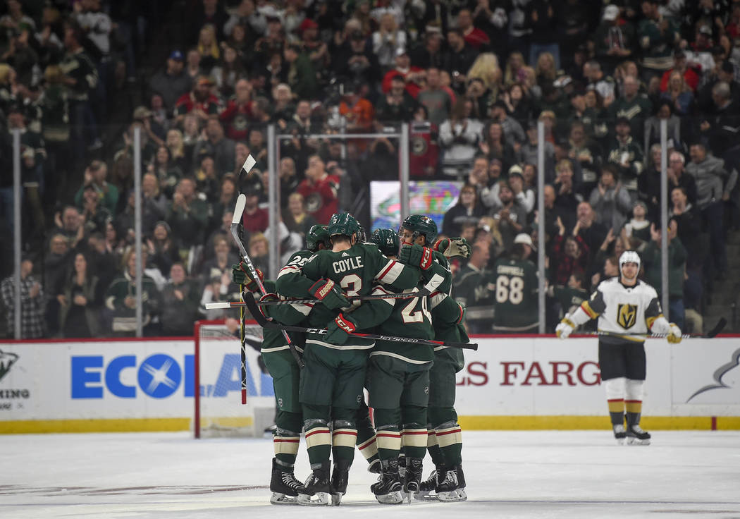 The Minnesota Wild celebrate after defenseman Mathew Dumba scored the first goal of the home opener against the Vegas Golden Knights in the first period during an NHL hockey game Saturday, Oct. 6, ...