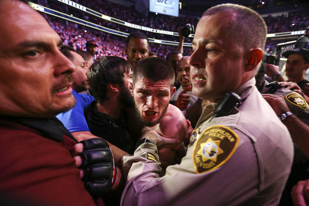Las Vegas police and security hold back Khabib Nurmagomedov after he defeated Conor McGregor at UFC 229 at T-Mobile Arena in Las Vegas on Saturday, Oct. 6, 2018. Chase Stevens Las Vegas Review-Jou ...