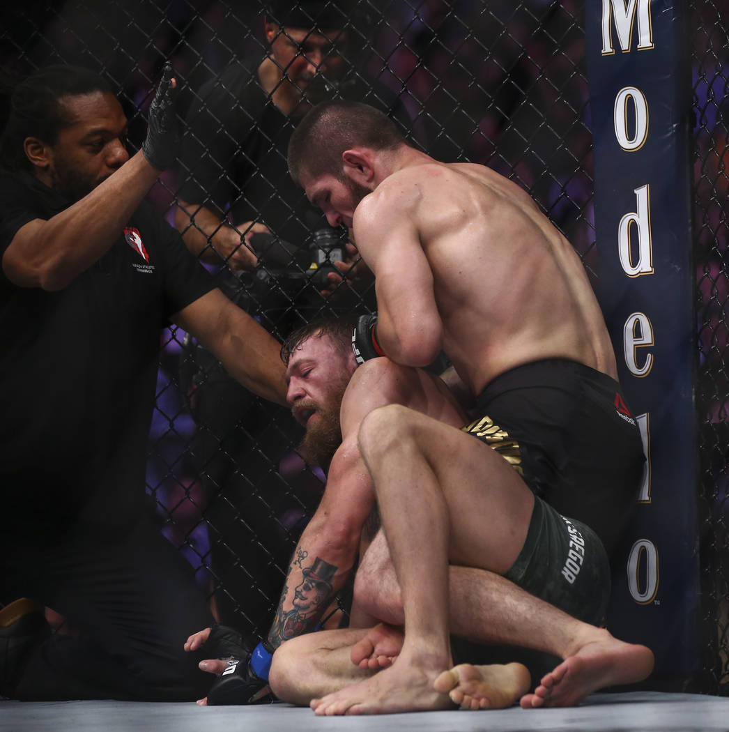 Khabib Nurmagomedov, right, forces Conor McGregor to tap out with a rear-naked choke in their lightweight title bout at UFC 229 at T-Mobile Arena in Las Vegas on Saturday, Oct. 6, 2018. Chase Stev ...