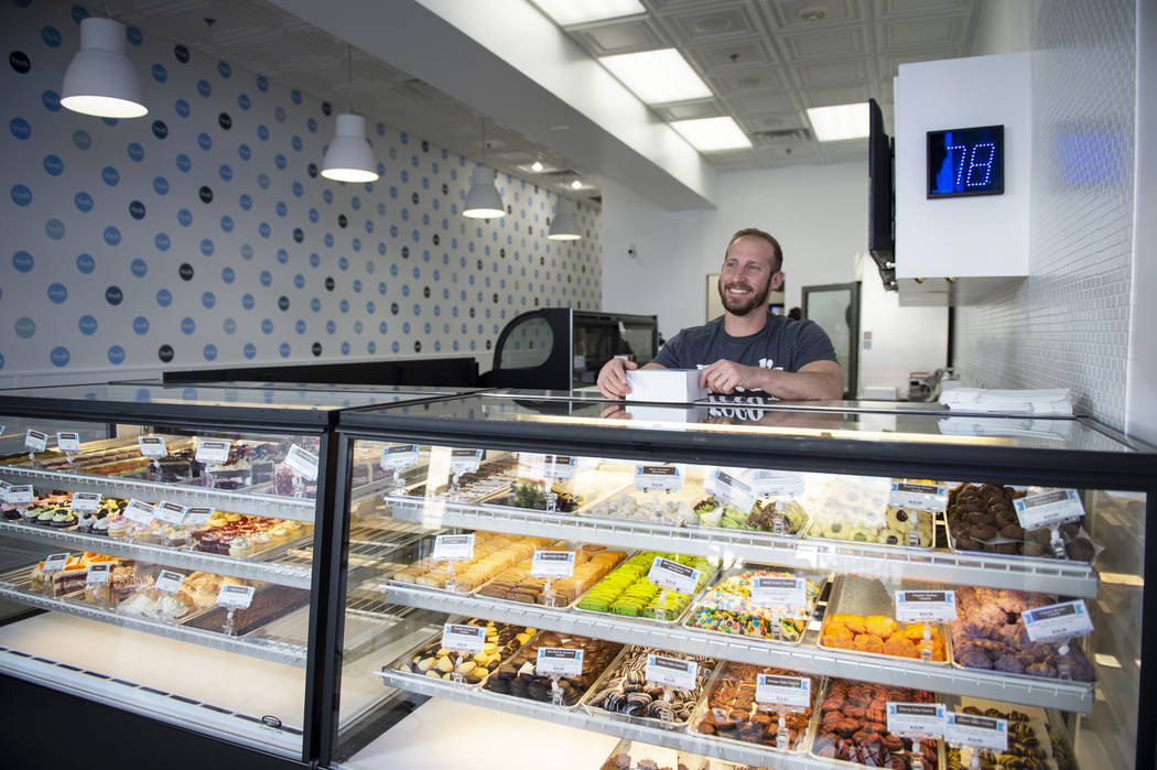 Max Jacobson-Fried, owner of Freed's Bakery, smiles behind the counter with a box full of various sweet treats in Freed's newest location at 6475 N. Decatur Blvd. in the Shadow Mountain Marketplac ...