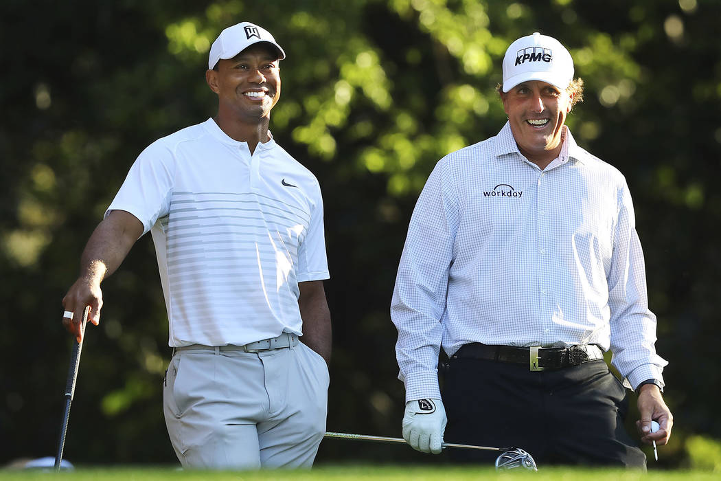 Tiger Woods, left, and Phil Mickelson share a laugh on the 11th tee box while playing a practice round for the Masters golf tournament at Augusta National Golf Club in Augusta, Ga., Tuesday, April ...