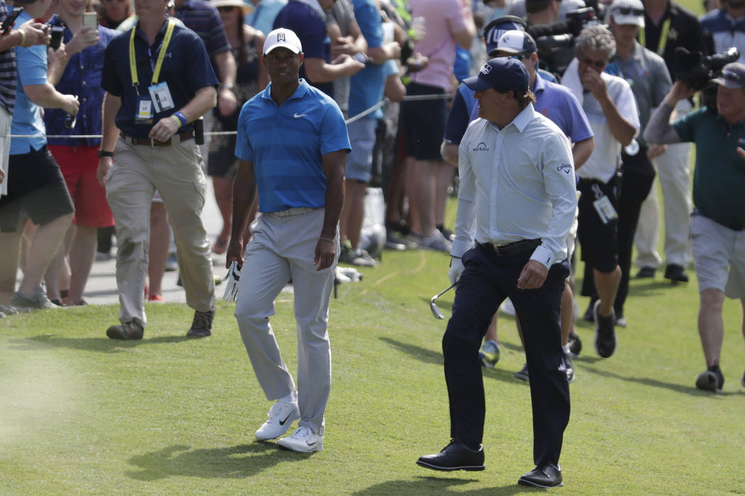 Tiger Woods, left, and Phil Mickelson, right, walks down the 10th fairway during the first round of the Players Championship golf tournament, Thursday, May 10, 2018, in Ponte Vedra Beach, Fla. (AP ...