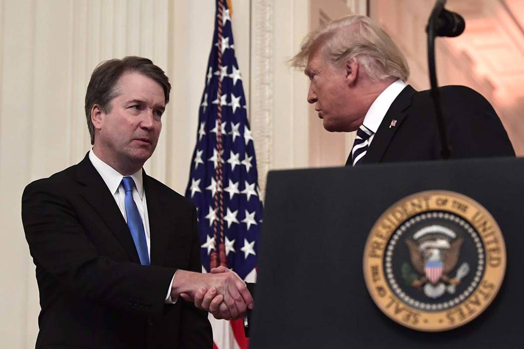 President Donald Trump, right, shakes hands with Supreme Court Justice Brett Kavanaugh before a ceremonial swearing in in the East Room of the White House in Washington, Monday, Oct. 8, 2018. (Sus ...