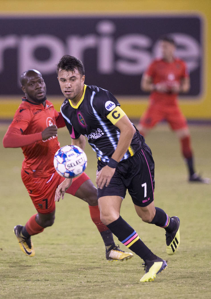 Las Vegas Lights FC midfielder Carlos Alvarez (7) pushes the ball up field past Phoenix Rising forward Billy Forbes (7) in the first half on Wednesday, Oct. 10, 2018, at Cashman Field, in Las Vega ...
