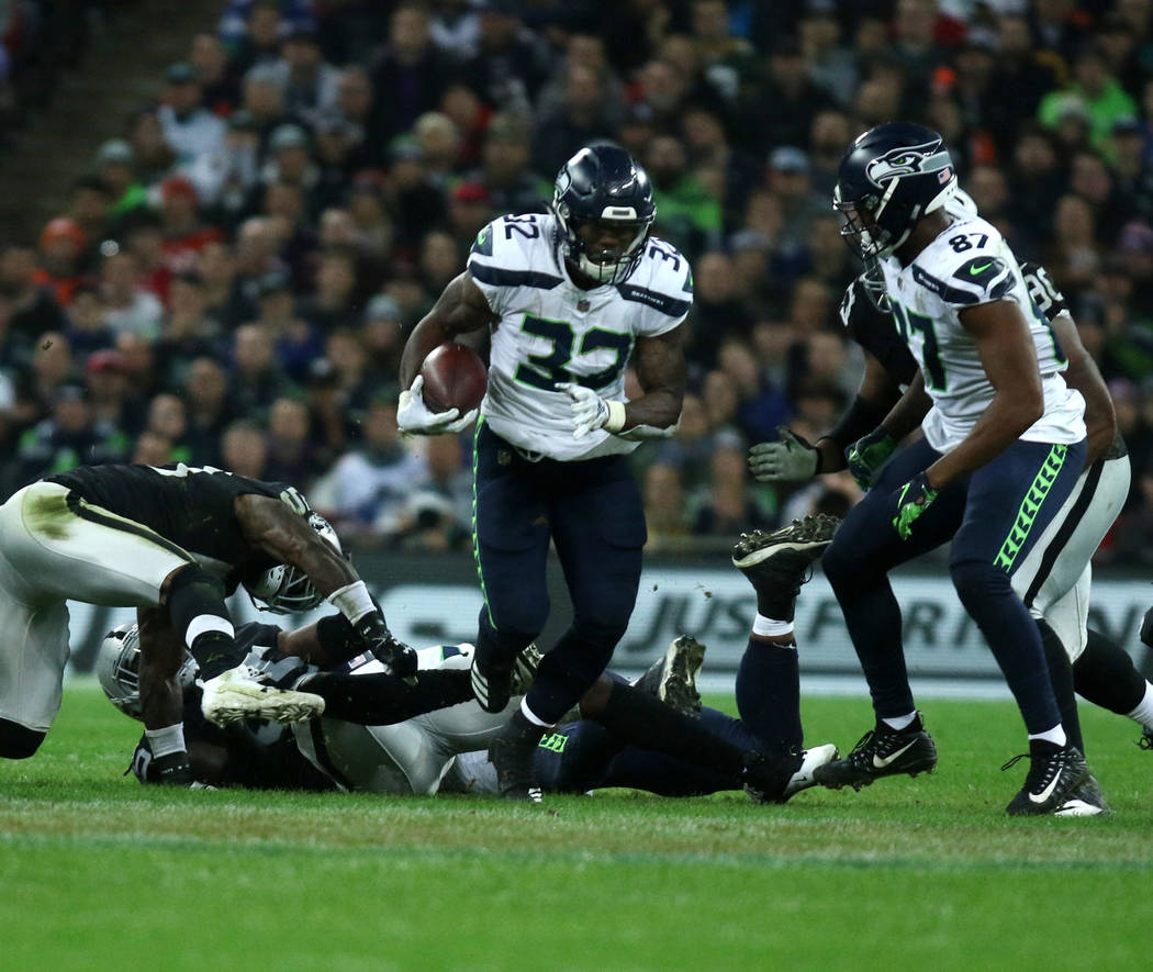 Seattle Seahawks running back Chris Carson (32) runs with the football during the first half of an NFL game against the Oakland Raiders at Wembley Stadium in London, England, Sunday, Oct. 14, 2018 ...