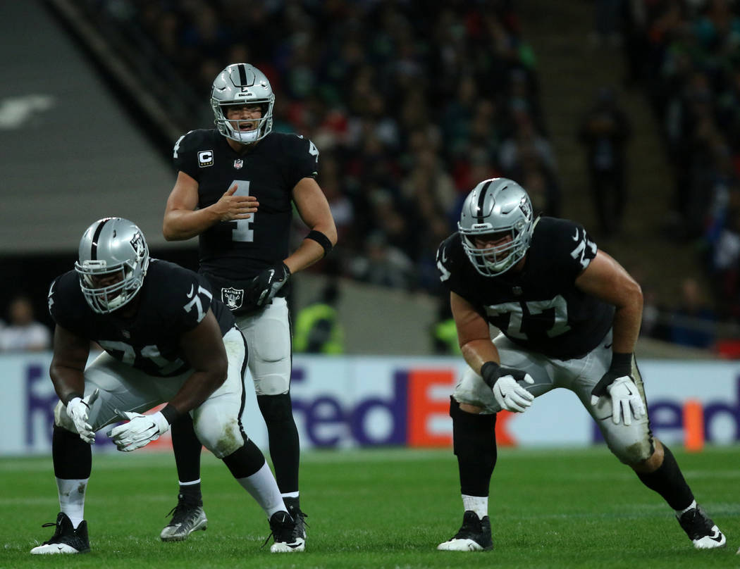Oakland Raiders quarterback Derek Carr (4) calls a play as offensive tackle Justin Murray (71) and offensive tackle Kolton Miller (77) are set on the line of scrimmage during the first half of an ...