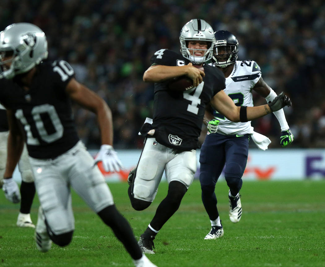 Oakland Raiders quarterback Derek Carr (4) runs with the football during the first half of an NFL game against the Seattle Seahawks at Wembley Stadium in London, England, Sunday, Oct. 14, 2018. He ...
